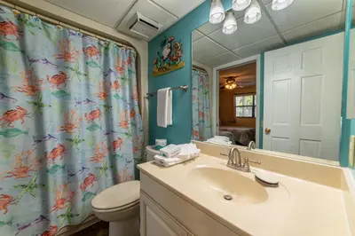 a bathroom with a sink and a toilet and a mirror at Edgewater Villa 2708 'Lost Shaker of Salt' in Panama City Beach