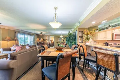 a kitchen and living room with a table and chairs at Edgewater Villa 2708 'Lost Shaker of Salt' in Panama City Beach