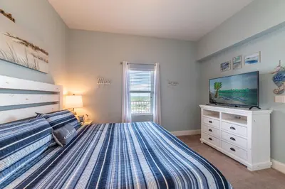 a bedroom with a large bed and a tv at Laketown Wharf 2117 'High Tide' in Panama City Beach