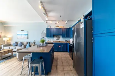 a kitchen and living room with blue cabinets at Laketown Wharf 2117 'High Tide' in Panama City Beach