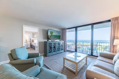 a living room with a view of the ocean at Edgewater 1-0303 'Salty Sunsets' in Panama City Beach