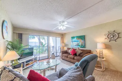 a living room with a couch and a table at Sugar Beach B04 'Seaside Escape' in Panama City Beach
