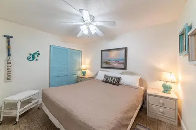 a bedroom with a bed and a ceiling fan at Sugar Beach B04 'Seaside Escape' in Panama City Beach