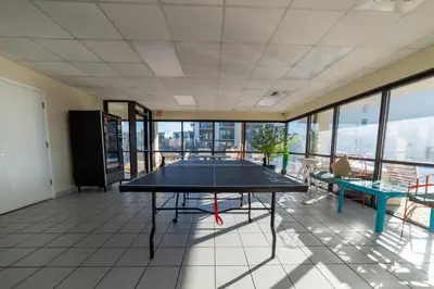 a ping pong table in a room with windows at Sugar Beach B04 'Seaside Escape' in Panama City Beach