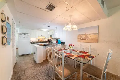 a kitchen with a table and chairs in a room at Sugar Beach B04 'Seaside Escape' in Panama City Beach
