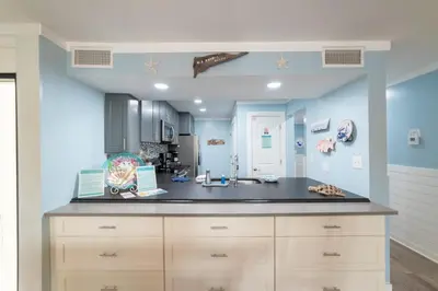 a kitchen with blue walls and a counter top at Edgewater Villa 0912 'Villa de sol' in Panama City Beach