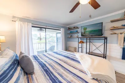 a bedroom with a bed and a tv on the wall at Edgewater Villa 0912 'Villa de sol' in Panama City Beach
