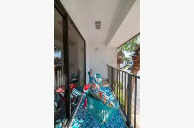a balcony of a house with blue and white sheets at Edgewater Villa 0912 'Villa de sol' in Panama City Beach