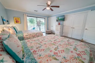 a bedroom with two beds and a ceiling fan at Edgewater Villa 0912 'Villa de sol' in Panama City Beach
