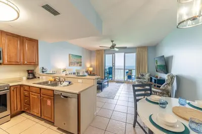 a kitchen and dining room with a table and a dining room at Seychelles 1602 'Ocean Pearl' in Panama City Beach