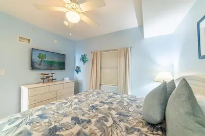 a bedroom with a bed and a ceiling fan at Seychelles 1602 'Ocean Pearl' in Panama City Beach