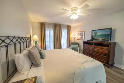a bedroom with a bed and a flat screen tv at Edgewater Villa 1104 'Sandy Feet Retreat' in Panama City Beach