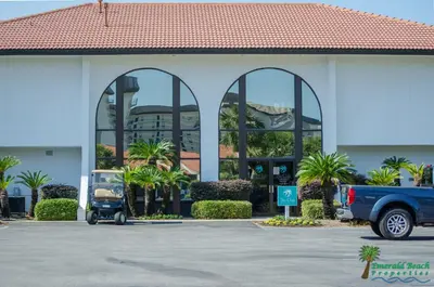 a blue truck parked in a parking lot in front of a building at Edgewater Villa 1104 'Sandy Feet Retreat' in Panama City Beach