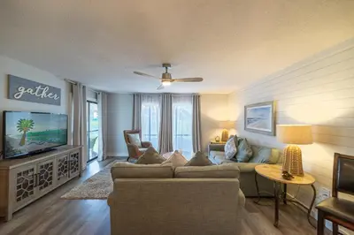 a living room with a couch and a tv at Edgewater Villa 1104 'Sandy Feet Retreat' in Panama City Beach