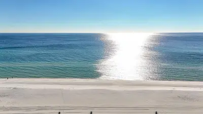 a beach with the sun reflecting on the water at Sunbird 0503W 'Big O's Condo' in Panama City Beach
