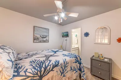 a bedroom with a bed and a ceiling fan at Sunbird 0503W 'Big O's Condo' in Panama City Beach