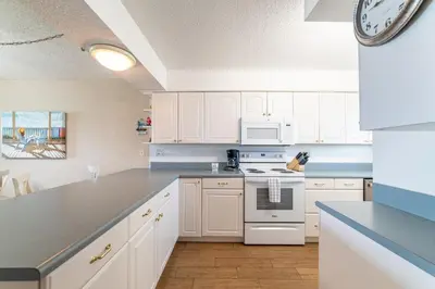 a kitchen with white cabinets and a stove top oven at Regency Towers 0407 'The Memory Maker' in Panama City Beach
