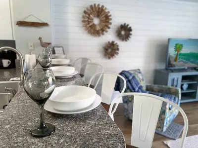 a table with white plates and wine glasses on it at Shores of Panama 1925 'Sunset Shores' in Panama City Beach