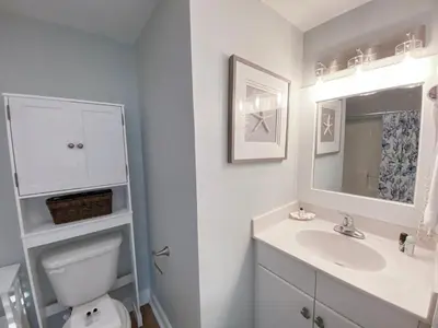 a white bathroom with a sink and a toilet at Shores of Panama 1925 'Sunset Shores' in Panama City Beach
