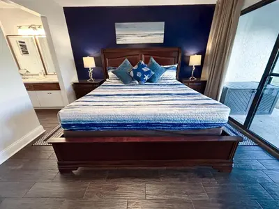 a bedroom with a large bed with blue walls at Edgewater Villa 0608 'Sunny by the Sea' in Panama City Beach