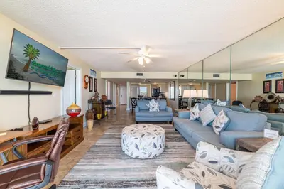 a living room with blue couches and a tv at Edgewater 2-0409 'Paradise City' in Panama City Beach