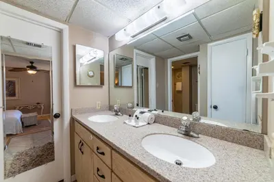a bathroom with two sinks and a large mirror at Edgewater W208 Beach Bungalow Bliss in Panama City Beach