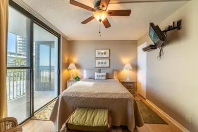 a bedroom with a bed and a ceiling fan at Edgewater W208 Beach Bungalow Bliss in Panama City Beach