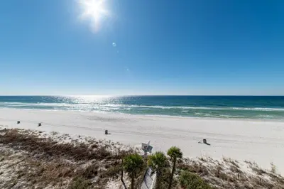 a beach with people walking on the sand and the ocean at Edgewater W208 Beach Bungalow Bliss in Panama City Beach