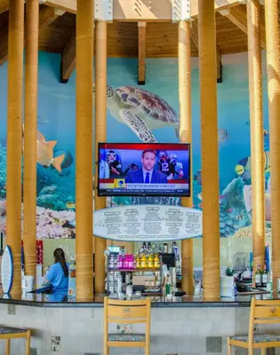 a bar with a television on the wall of a restaurant at Edgewater 3-0409 'Sunset Place' in Panama City Beach