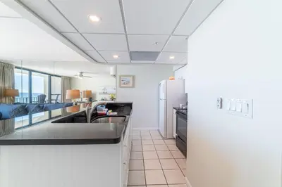 a kitchen with a sink and a refrigerator at Edgewater 3-0409 'Sunset Place' in Panama City Beach