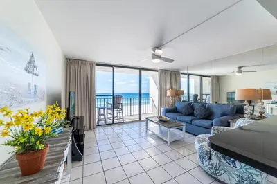 a living room with a blue couch and a view of the ocean at Edgewater 3-0409 'Sunset Place' in Panama City Beach