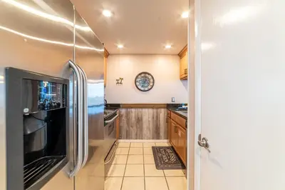 a kitchen with a stainless steel refrigerator and wooden cabinets at Edgewater W102 'Tides Edge' in Panama City Beach