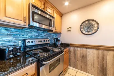 a kitchen with a stove and a clock on the wall at Edgewater W102 'Tides Edge' in Panama City Beach