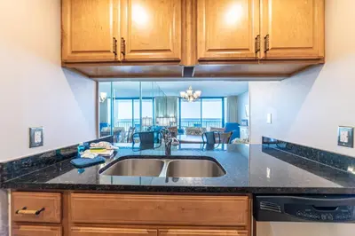 a kitchen with a sink and a living room at Edgewater W102 'Tides Edge' in Panama City Beach