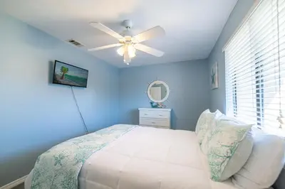 a blue bedroom with a bed and a ceiling fan at Gulf Highlands-Sunset On The Gulf in Panama City Beach