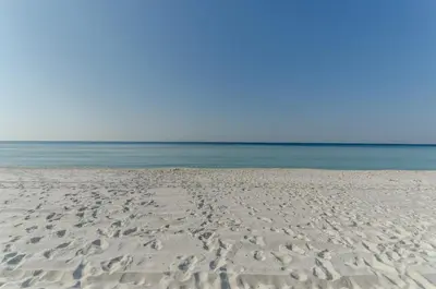 a sandy beach with the ocean in the background at Gulf Highlands-Sunset On The Gulf in Panama City Beach