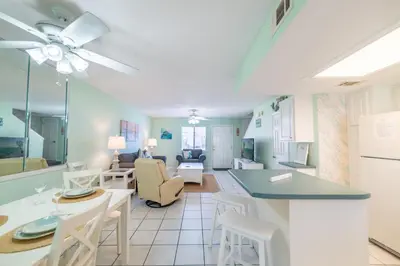 a kitchen and living room with a table and chairs at Gulf Highlands-Sunset On The Gulf in Panama City Beach