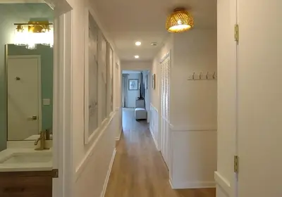 a hallway with a bathroom with a sink and a toilet at Edgewater Villa 1105 'Villa Ardea' in Panama City Beach