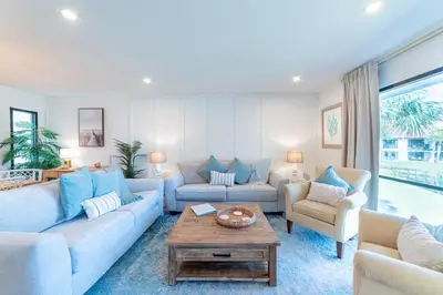 a living room with couches and a table at Edgewater Villa 1105 'Villa Ardea' in Panama City Beach