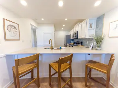 a kitchen with two chairs and a counter with a sink at Edgewater Villa 1105 'Villa Ardea' in Panama City Beach