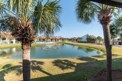 a pond with two palm trees in a park at Edgewater Villa 1105 'Villa Ardea' in Panama City Beach