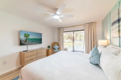 a bedroom with a large white bed and a window at Edgewater Villa 1105 'Villa Ardea' in Panama City Beach