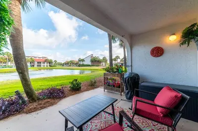 a porch with a table and chairs and a view of the water at Edgewater Villa 1101 'Sunset Paradise At Edgewater' in Panama City Beach