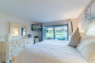 a bedroom with a white bed and a large window at Edgewater Villa 1101 'Sunset Paradise At Edgewater' in Panama City Beach