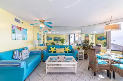 a living room with a blue couch and chairs at Sunbird 0703E 'Beachhead Paradise' in Panama City Beach