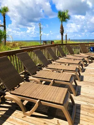 a row of chaise lounges on a boardwalk at the beach at Sunbird 0703E 'Beachhead Paradise' in Panama City Beach