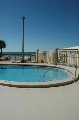 a large swimming pool with the ocean in the background at Sunbird 0703E 'Beachhead Paradise' in Panama City Beach