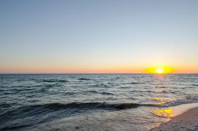 a sunset over the ocean with a sandy beach at Sunbird 0703E 'Beachhead Paradise' in Panama City Beach