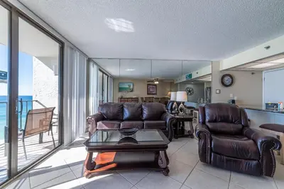 a living room with two leather chairs and a table at Edgewater 3-1010 'The Salty Coconut' in Panama City Beach