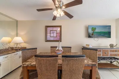 a kitchen with a ceiling fan and a table with chairs at Edgewater 3-1010 'The Salty Coconut' in Panama City Beach